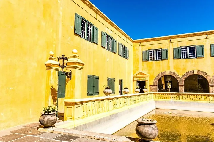 Innenhof mit gelben Wänden und einem Pool in der Burg der Guten Hoffnung.