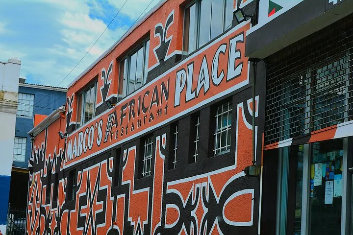 Außenansicht des Restaurants Marco's African Place mit lebhaften, gemusterten Wänden.